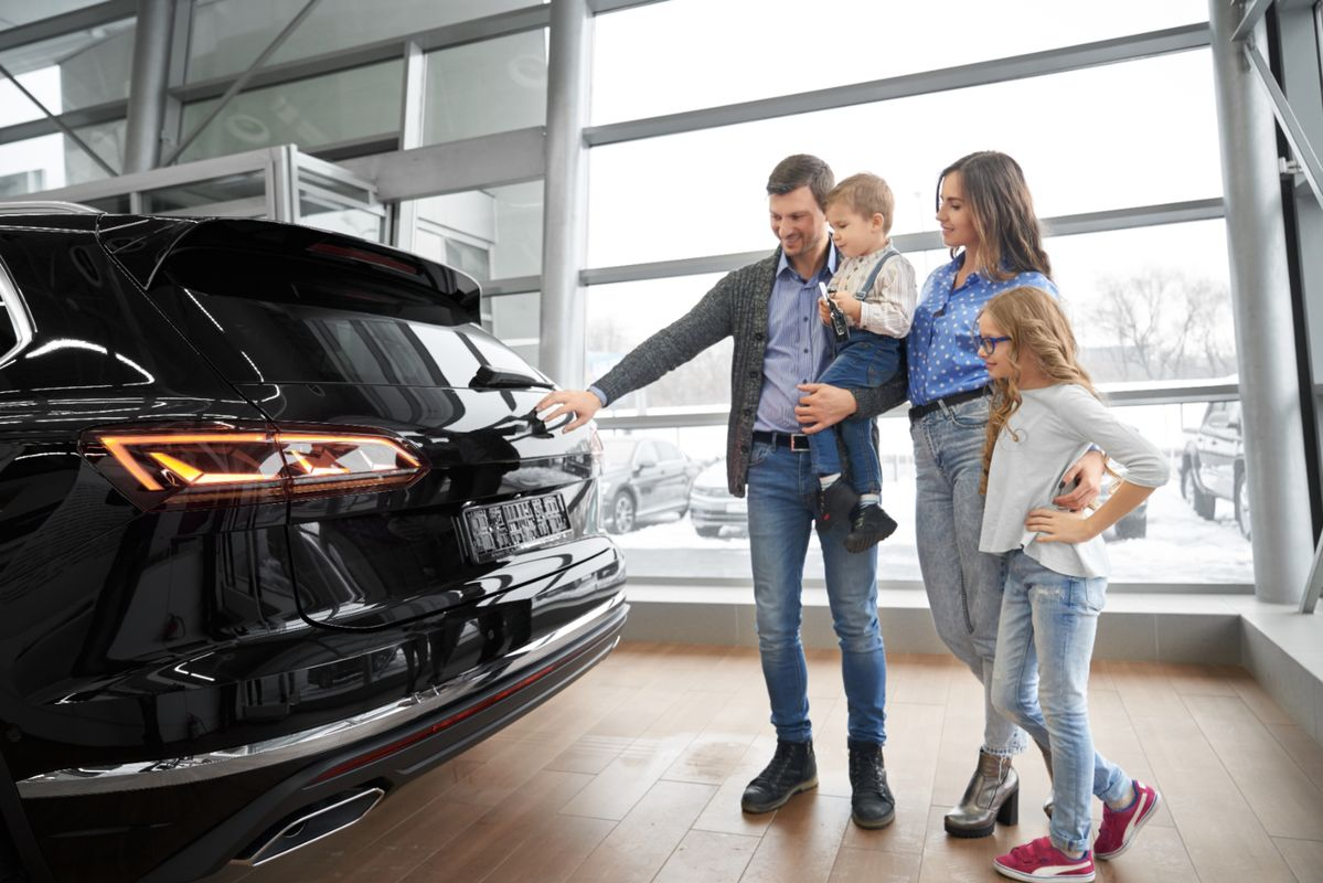 Family choosing a new car at a dealership