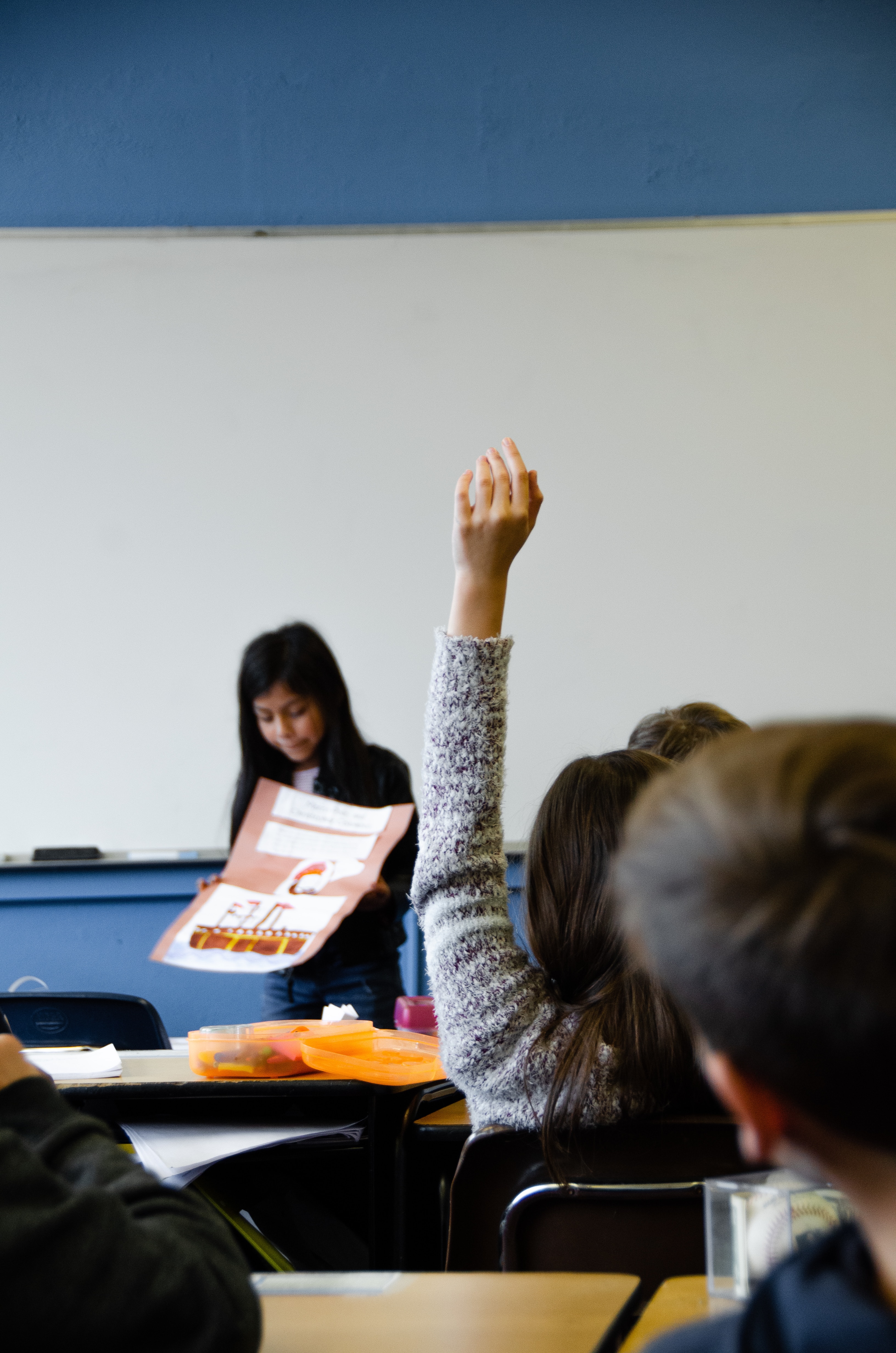 Student raising their hand in class